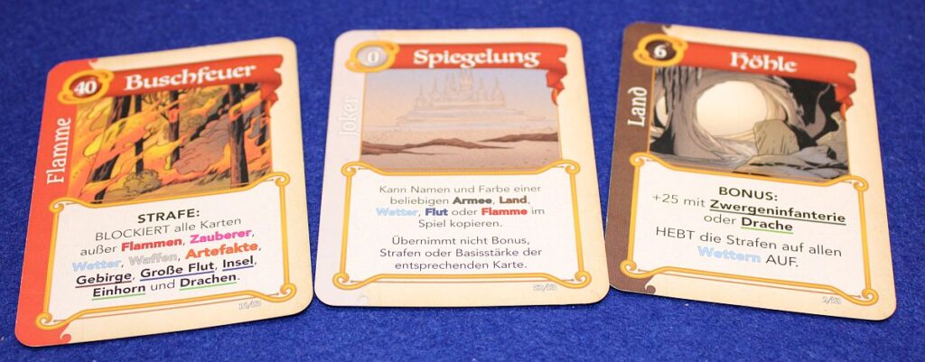 Drei beispielhafte Karten des Spiels "Fantastische Reiche", die Schlüsselwörter enthalten.